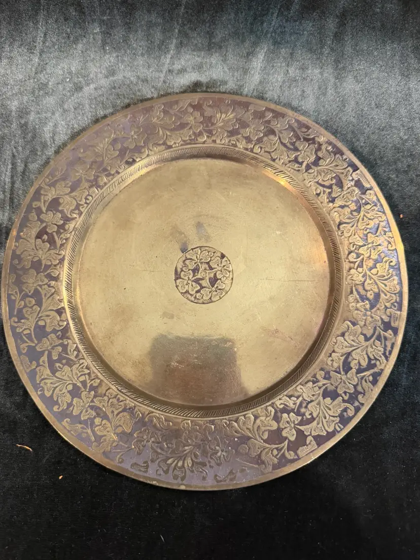vintage brass plate featuring detailed etched floral motifs on the border and a matching central medallion, likely of Anglo-Indian origin.