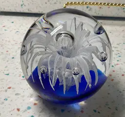 #01 Large blown glass paperweight, 3 1/2” round and high. Rich blue base, white flower, and controlled bubbles.