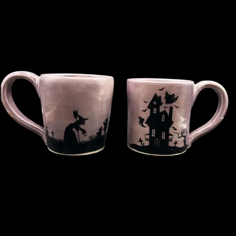 #217B Pair Of Halloween Themed Hand Made Pottery Mugs. Haunted House, Witches, Trick Or Treaters Smoky Purple With Black Silhouette  Scenes Around Both. 
Pottery By Debbie Stamped On Bottom.