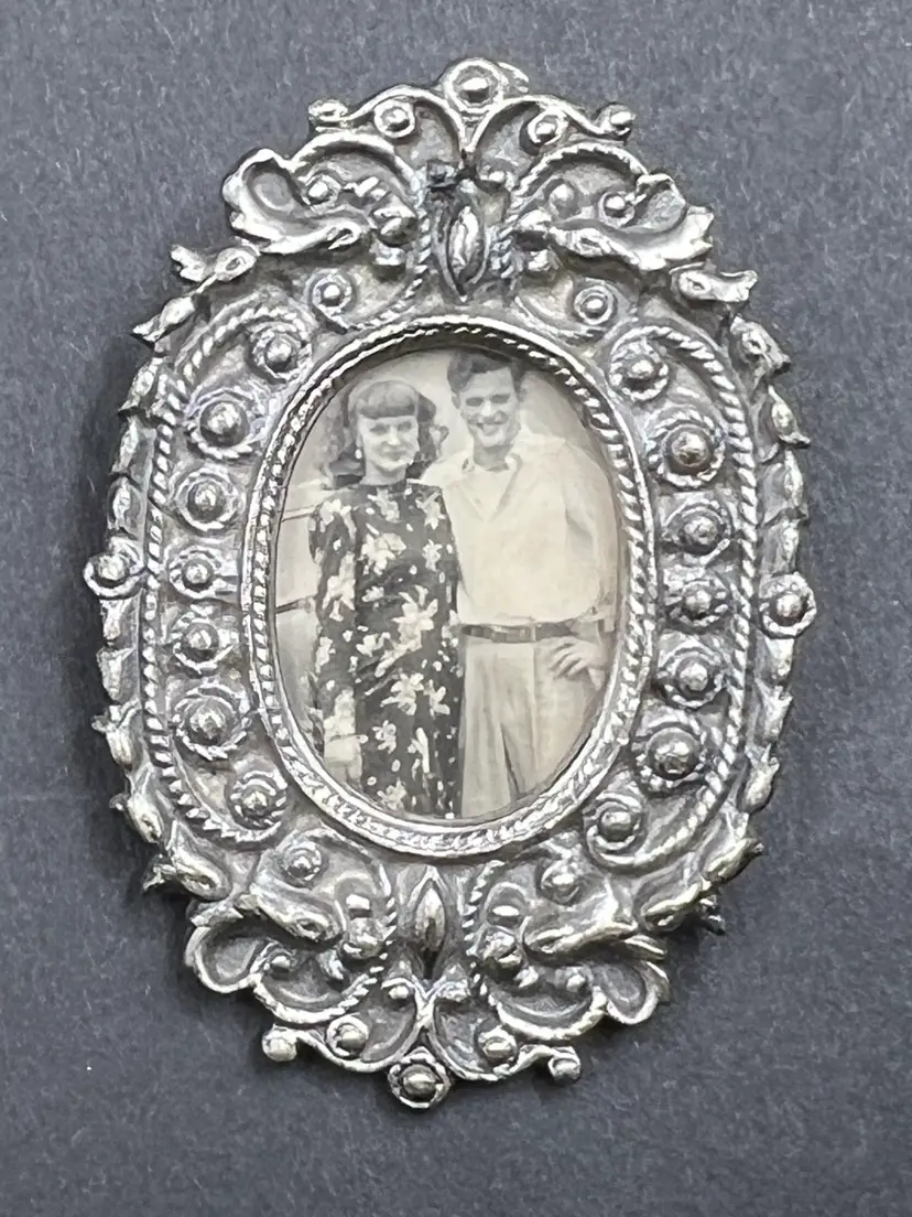 Ornate oval Silver Tone filigree picture frame with a vintage couple photograph.2”