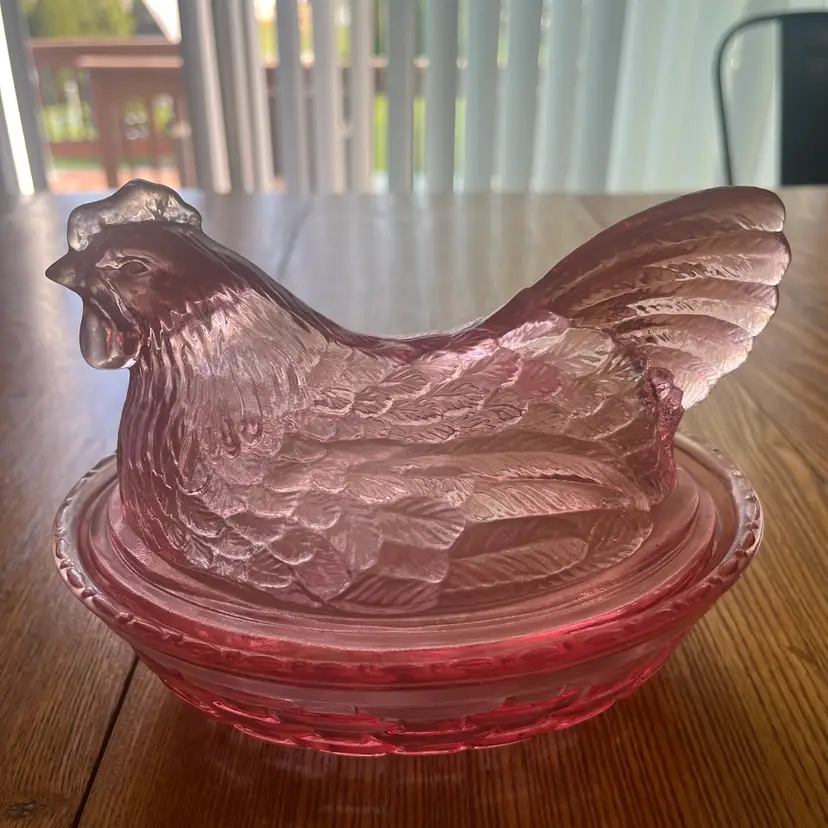 A pink glass hen on a nest covered bowl,  by Longaberger. 8” X6”