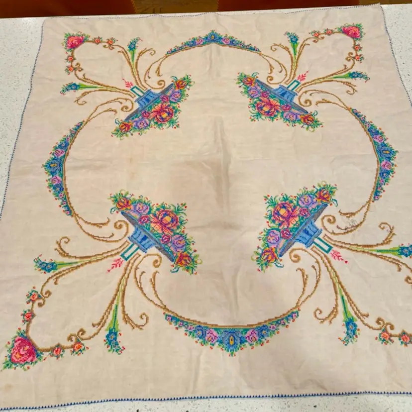Vintage 32” embroidered cotton tablecloth featuring a cross-stitch floral basket design