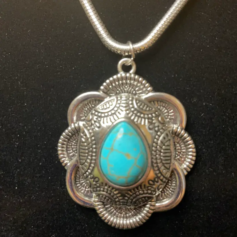 18” Silver-tone necklace with faux turquoise in a Southwestern concho-style 2” pendant.