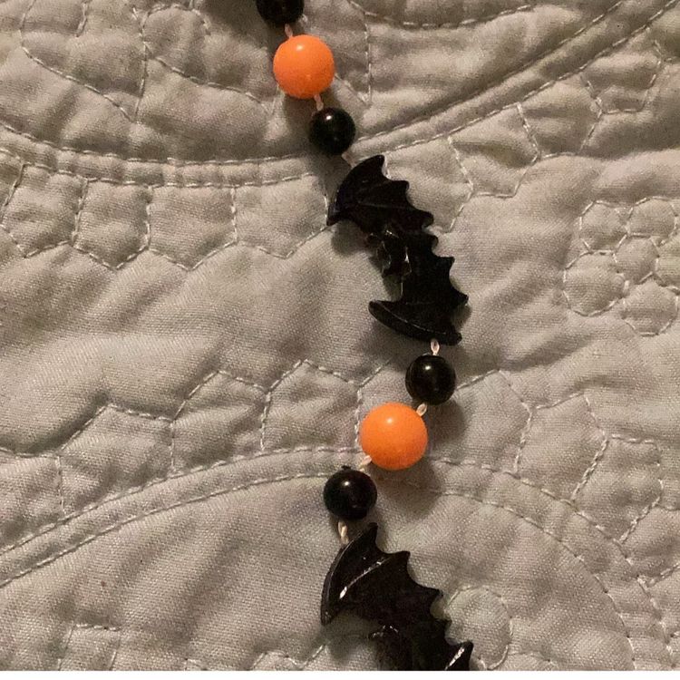 Halloween necklace, black bats, and orange beads can be turned into a bracelet