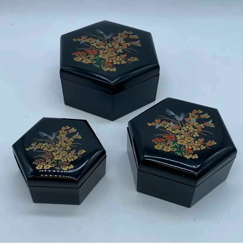 #4112 A set of three Thai hexagonal lacquerware boxes with floral decoration.