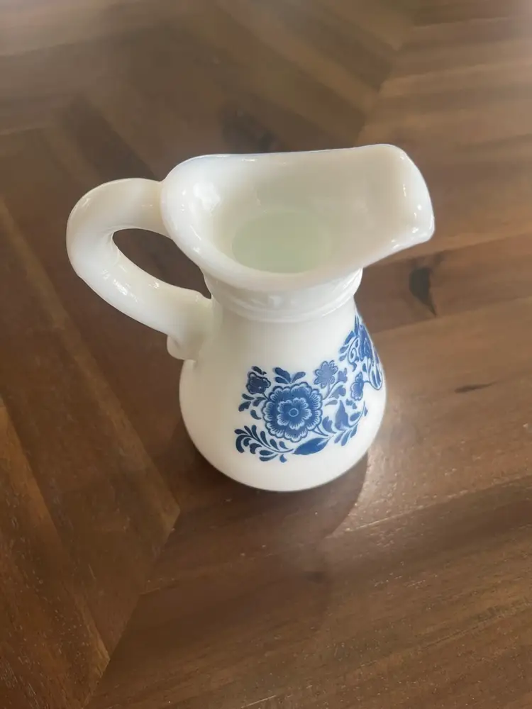 Vintage Avon milk glass bath oil pitcher with blue floral pattern and saucer. 6.5” Tall - Three Pieces Pitcher, Base And Stopper