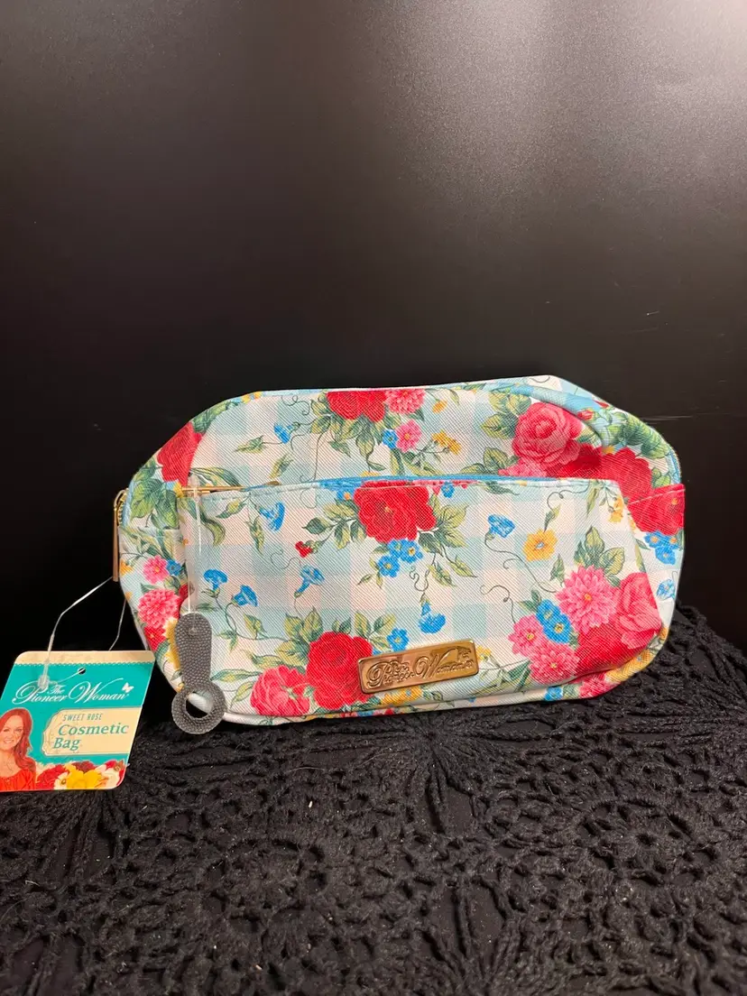 2022-The Pioneer Woman-Brand New Cosmetic Bag w/ Tags Still on. Beautiful Floral Pattern w/ Blue/White Gingham. One Main Zippered Compartment and a Smaller Zippered Pocket on Outside of Bag. Lot 38
