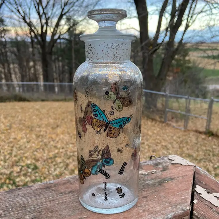 Georges Briard, Glass Apothecary Decanter / Glass Bottle With Stopper. Colorful Butterflies: Blue, Green, Red/Pink And Gold-toned Foiled Butterflies, with Foliage, Sun, And Stars Motif. 8.5”h.