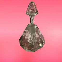 A collectible cut crystal perfume bottle with a faceted, pyramid-shaped base and a pointed stopper