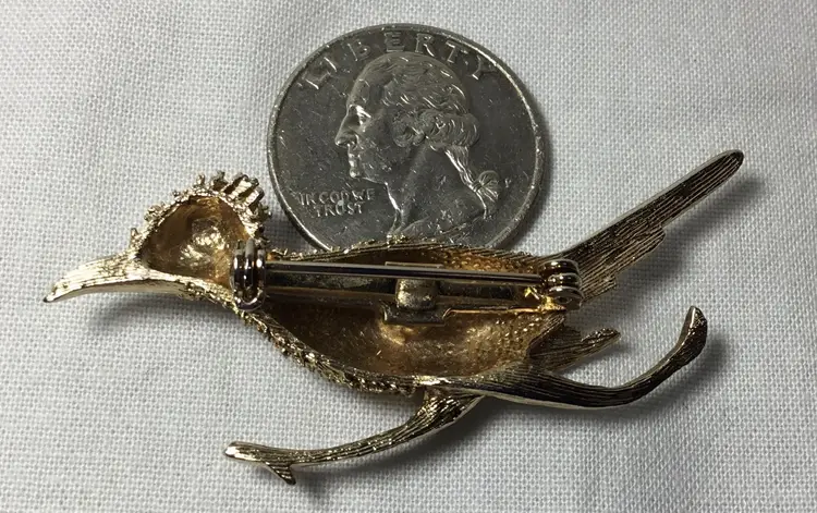Roadrunner brooch, gold tone, red rhinestone eye, textured 2.25"