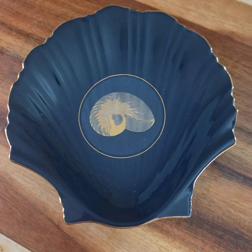 decorative shell plate features navy blue finish with central nautilis shell design gold trim