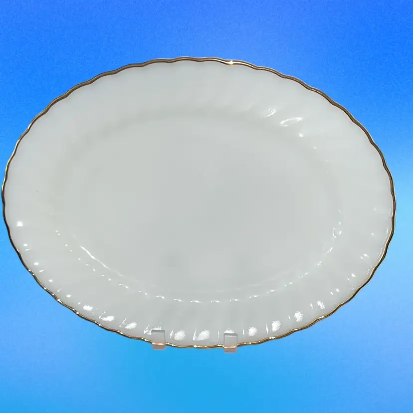 This is a vintage Anchor Hocking milk glass platter with gold trim.12x10”,