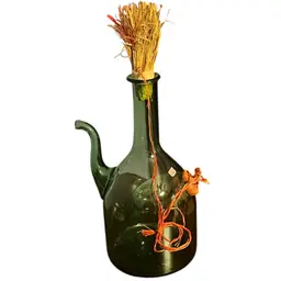 Vintage hand-blown green glass decanter with ice chamber and decorative twine. - Sticker States Made In Italy.
 Bottle is 13 inches high
From Edge Of Spout To Edge Of Bottle Is 8 Inches .