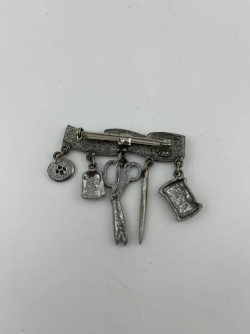 Pewter Toned "Seamstress" Pin.  Has charms:  Spool of thread, Needle, Scissor, Thimble & Button on Tape Measure