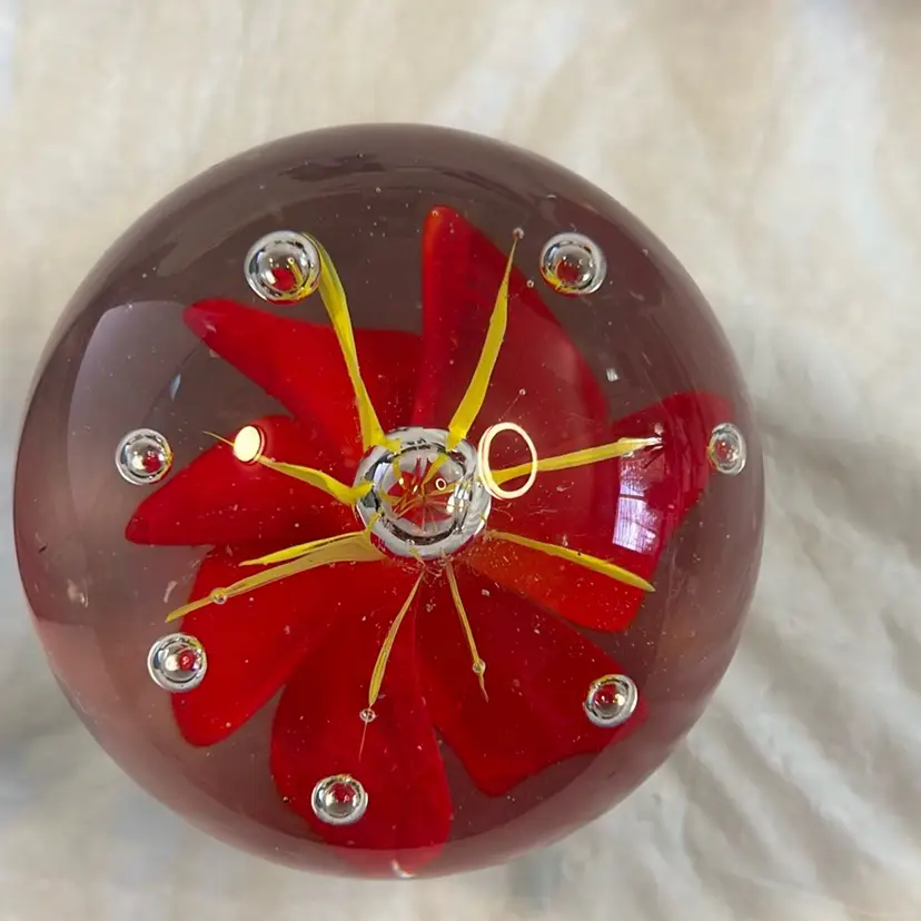 Red And Yellow Flower Paperweight With Bubbles Around The Petals. 3” Round And 2 1/2” Tall. Several Small Dark Flecks Within Clear Glass And Flecks In Bottom