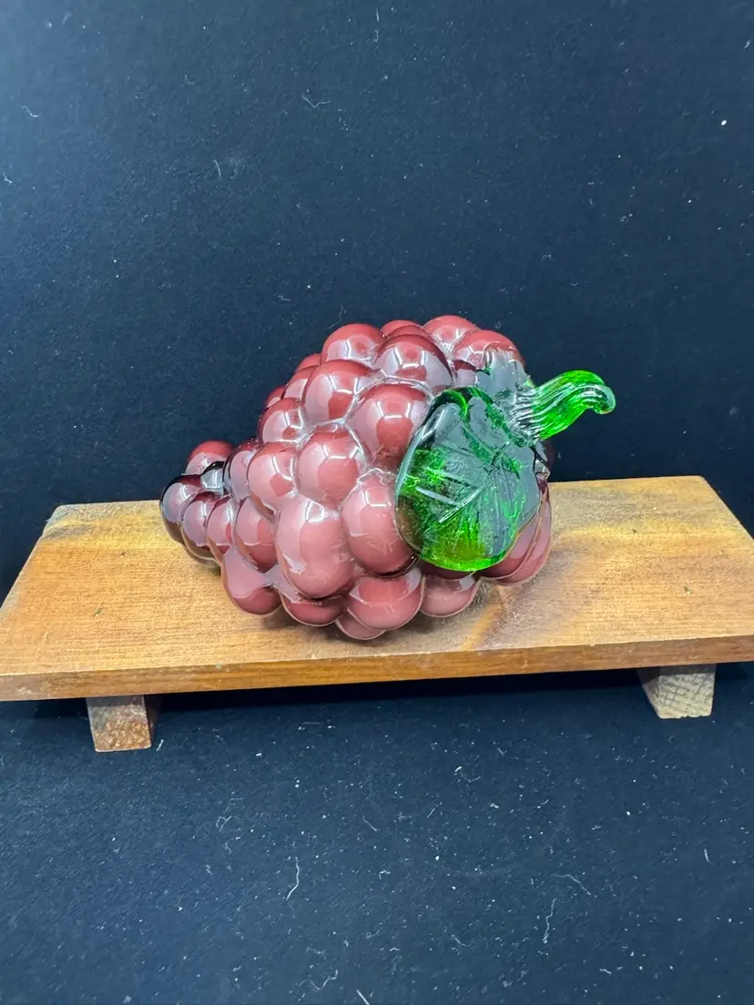Vintage glass art sculpture of a purple grape cluster with a green stem and leaf