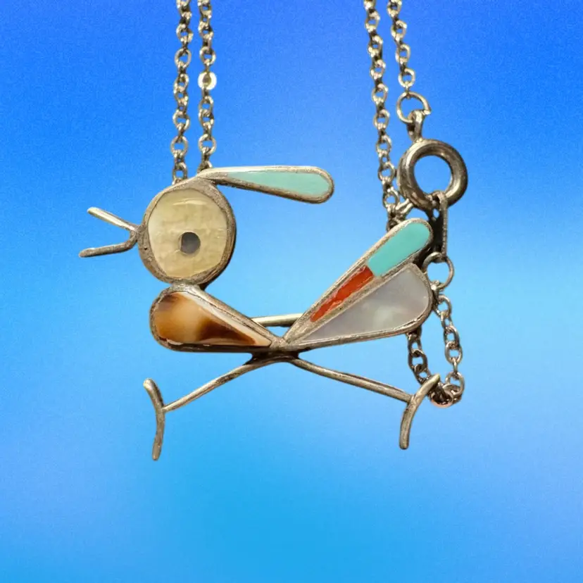A Zuni inlaid roadrunner pendant on a silver chain.
