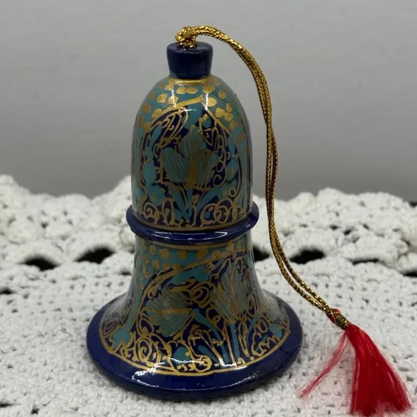 Glowy Hand-painted paper mache bell ornament with gold and teal floral motifs.