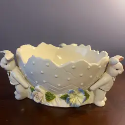 A whimsical ceramic Easter bunny bowl with a scalloped, egg-shaped rim.  About 9 inches in diameter and 3.5 inches tall.