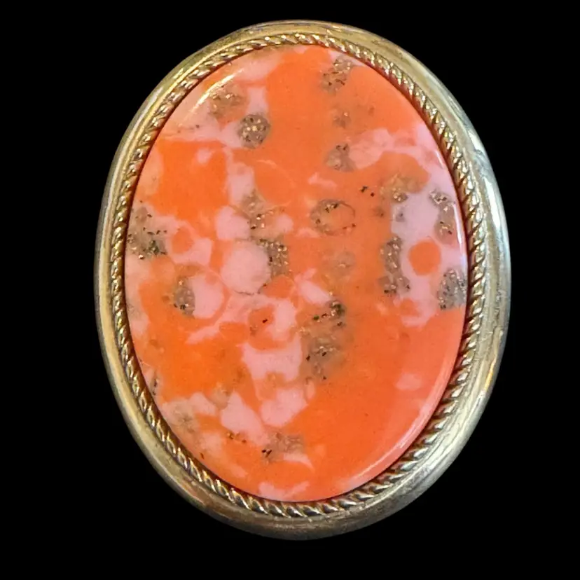 This is a vintage Sarah Coventry Coraline brooch with a pink and gold-tone stone.