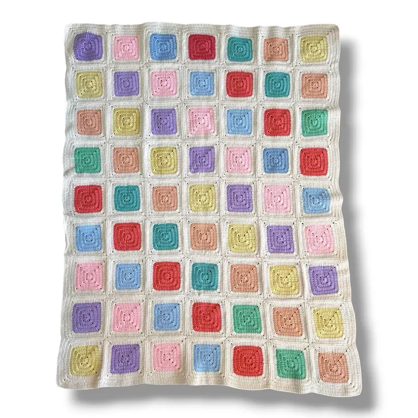 Hand Crocheted granny square baby blanket featuring colorful pastel squares joined together with a white border. 56 X 45“  Very Well Done