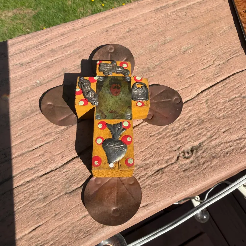 handcrafted Mexican Milagro cross, a traditional form of folk art typically made from wood and decorated with small metal charms