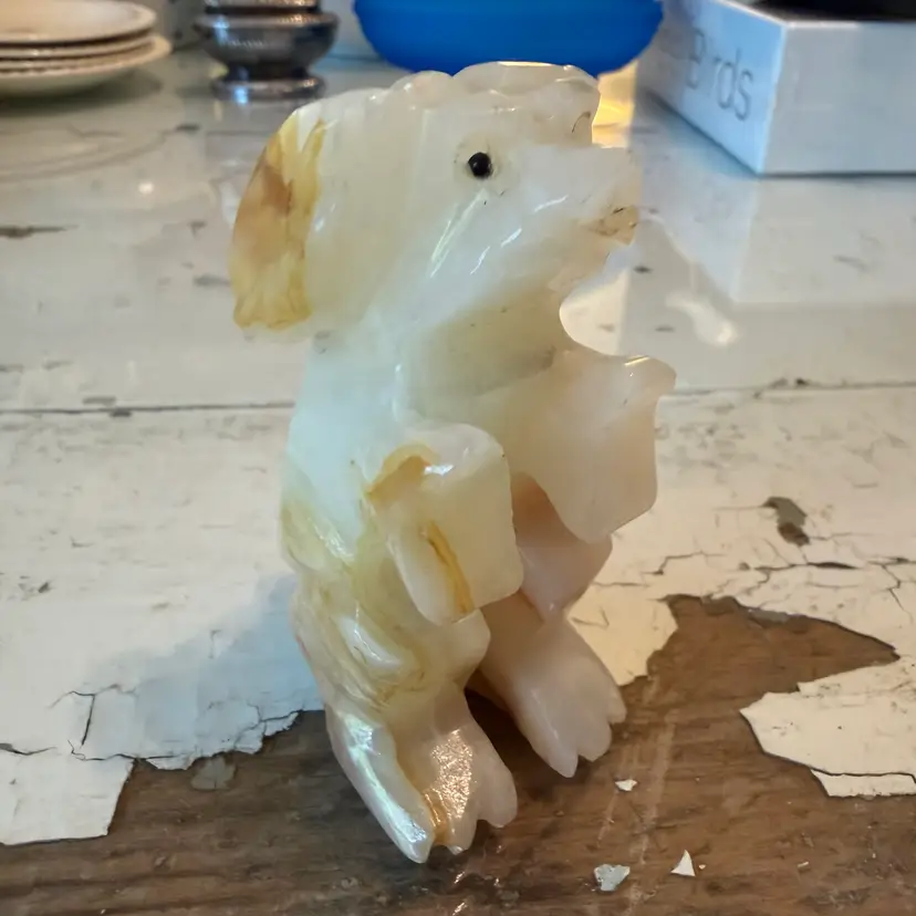 This vintage dog figurine is crafted from carved white and honey-colored onyx stone.