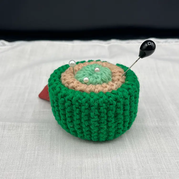 Hand knit Green Pin Cushion with Strawberry. Includes 3 Faux Pearl Pins And 1 Black Faux Pearl Hat Pin.
3.5” X 2.5”