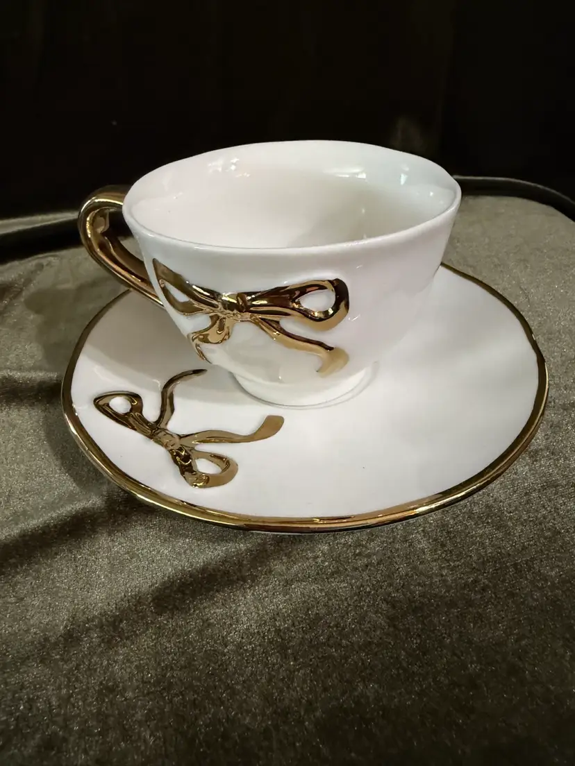 Beautiful white porcelain with Gold Accents And Gold Bows On Teacup & Saucer