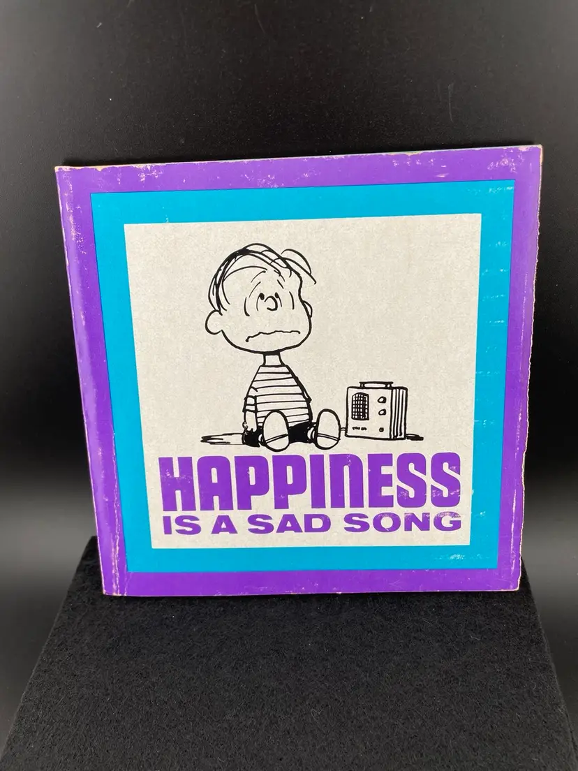 Peanut’s Happiness Is A Sad Song Paperback Book Featuring Linus