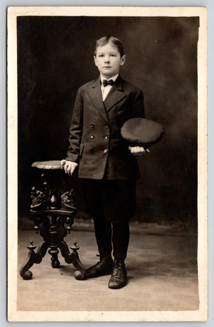 Postcard RPPC Dapper Young Boy in Peacoat Uniform Bowtie Holding Cap Real Photo  - 9101
