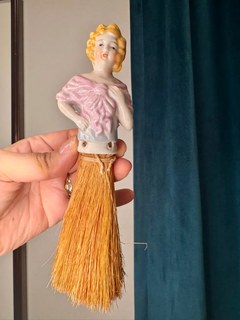 vintage 8” tall porcelain half-doll whisk broom, likely originating from Japan between the 1900s and 1920s.
