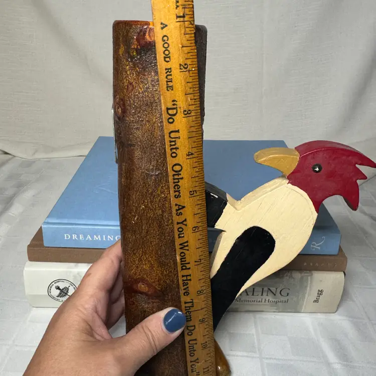 Handcrafted wooden log with a painted woodpecker decoration