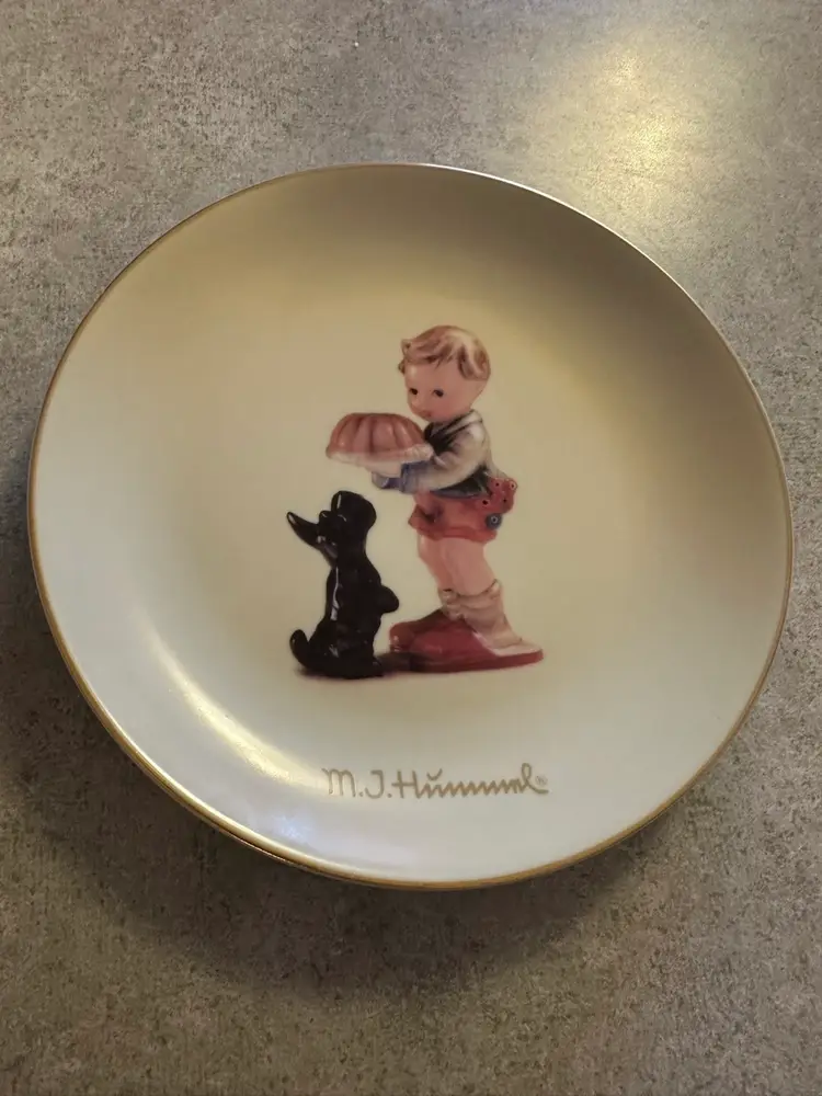 Porcelain collector plate titled
'Begging His Share' by M.I. Hummel for Goebel