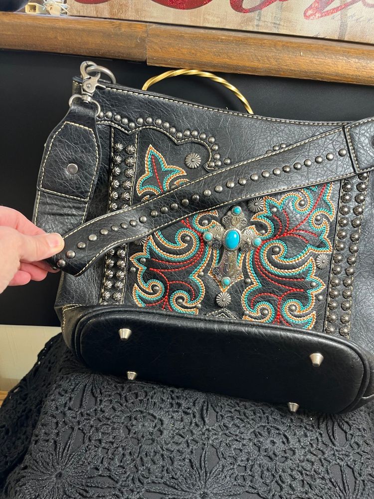 Montana West Shoulder Bag w/ Brushed Silver Toned Celtic Cross w/ Faux Turquoise.  Hardware is also Brushed Silver Toned. Multi Colored Thread in a BUTTERFLY Design.
