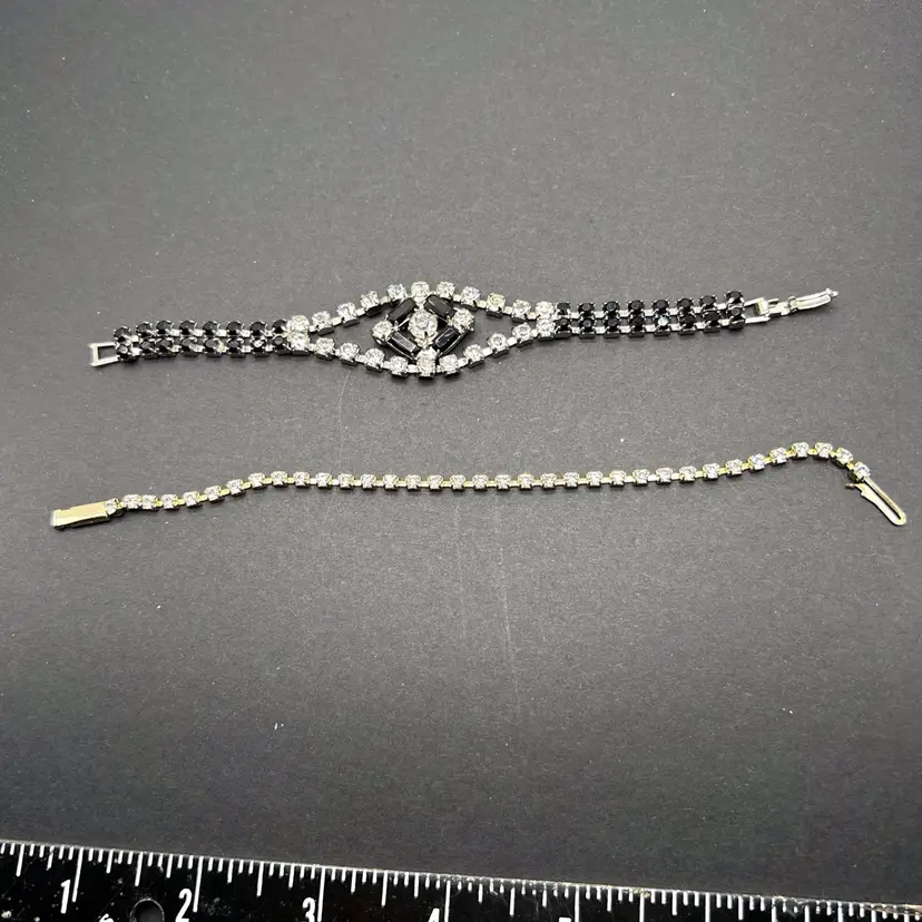 Two beautiful vintage, rhinestone bracelets one is a tennis bracelet with clear stones. Approximately 6 1/2 inches closed. The second is a dressier bracelet with black and clear rhinestones. Approximately 6 inches.  Neither are stamped.