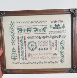 Framed Christmas cross-stitch sampler with holiday motifs and text.
Frame 9 1/2 x 11 .25 inches
