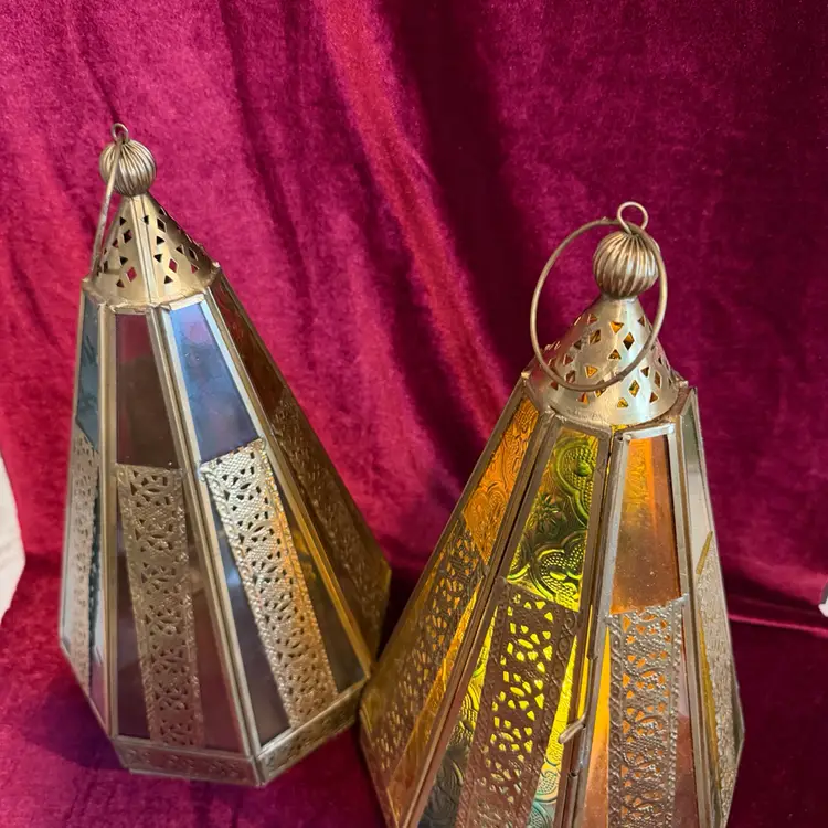 Vintage Moroccan-style Metal and colored glass candle lantern.  Price is for 1- Will sell both at discounted price. Note- Candle not included.

This Stunning Candle holder has pierced metal with yellow, pink, and blue glass panels.  Some of the panels are solid glass and some have a Moroccan type design.  The lantern has a metal loop for hanging at the top but also has feet and can sit on a table.  One panel is hinged and opens to place a Real candle or battery candle inside.  It is a truly beautiful piece!