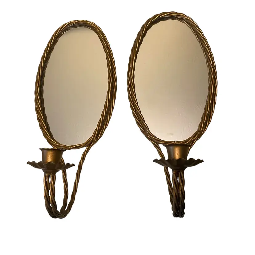 These vintage Hollywood Regency gold twisted rope mirror candle holders were likely produced by manufacturers like Homco or designed in the Italian gilt tole style during the 1960s or 1970s