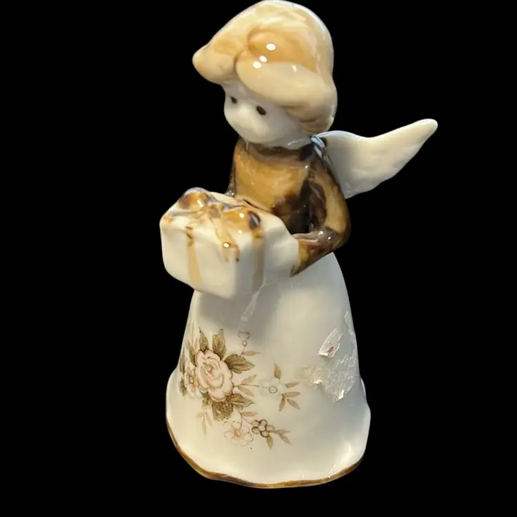 A vintage porcelain angel bell figurine holding a gift with floral decoration. Christmas 3.5”