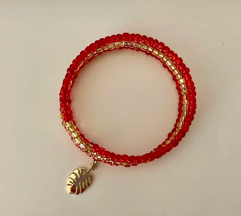 New, handmade wrap bracelet with red/gold glass beads and a gold tone leaf charm. Rich in color!