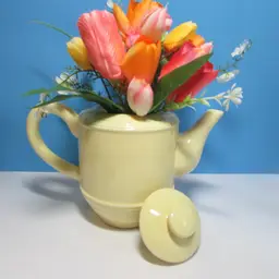 vintage pale yellow Cracker Barrel ceramic teapot with tulip flower arrangement