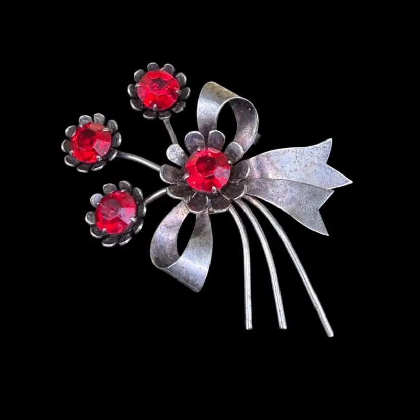 vintage sterling silver flower sprig brooch with red glass or crystal rhinestones.
