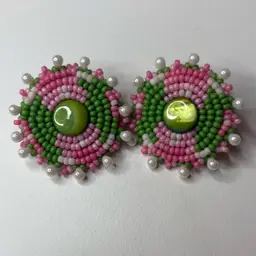 This is a pair of handmade pink and green seed bead stud earrings with a light green center. 1 3/8” Round