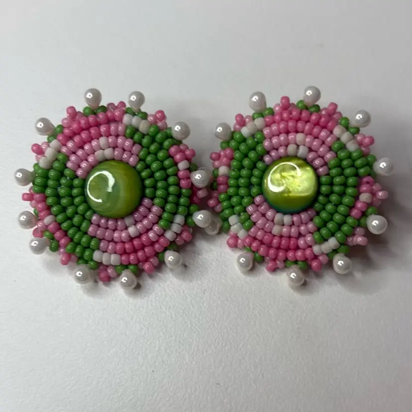 This is a pair of handmade pink and green seed bead stud earrings with a light green center. 1 3/8” Round