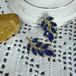 Clip On gold-tone leaf cluster earrings with marquise-cut royal blue rhinestone