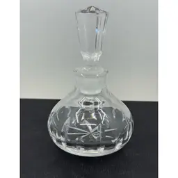 A cut crystal perfume bottle with a faceted stopper.