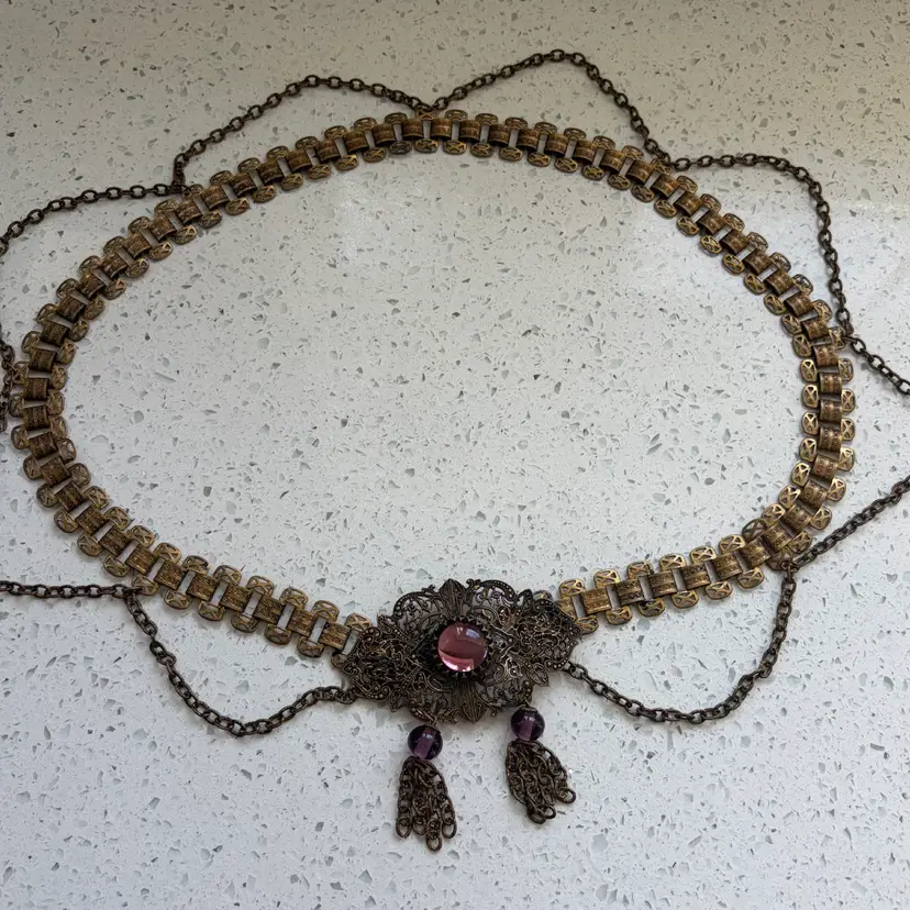 Absolutely Stunning 1890’s To Early 1900’s Brass With Amethyst Glass Belt. 31” Long.  Book Chain With Beautiful Filigree Work On The Buckle And The Draping Chains That Go All Around.  Simply Gorgeous Piece