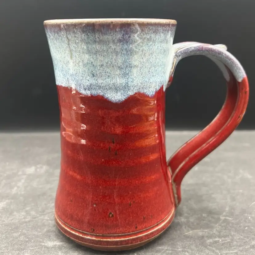 #419B Beautiful Signed Studio Pottery Mug, Coffee Cup Tall Hourglass Shaped With A Bluish Gray Drip Over Maroon Glaze.