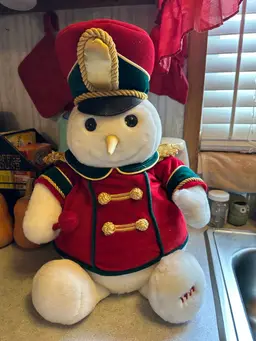 Plush snowman toy titled 'Snowden' in drum major uniform. 17 Inches